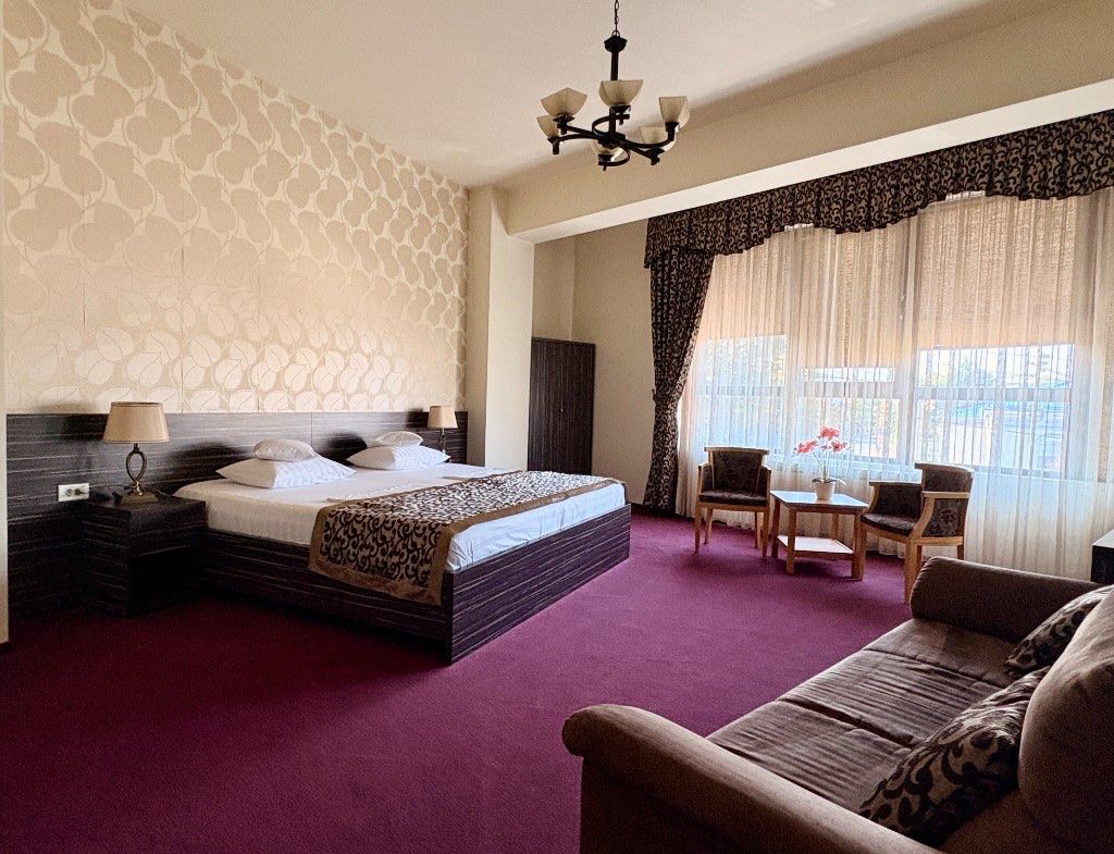 Apartament deluxe RIX Rooms — pat king, canapea și zonă de relaxare